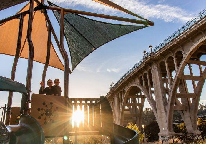 Children play at the playground that sits below the Colorado Street Bridge.